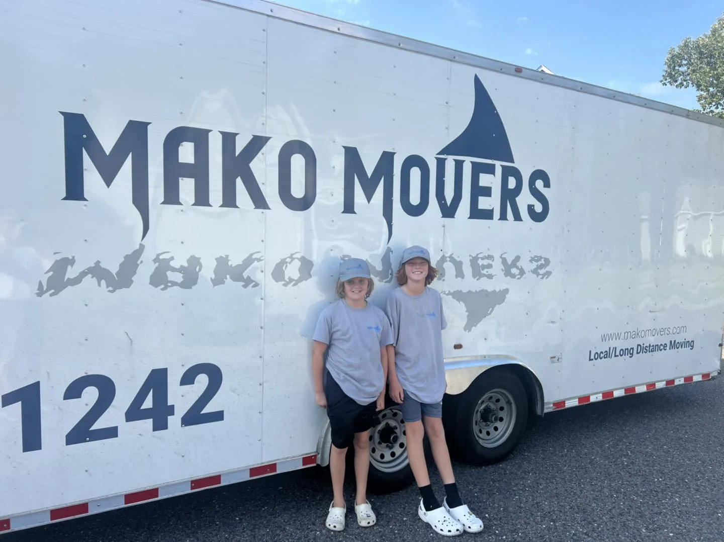 Mako Movers crew members beside a branded Charleston moving trailer