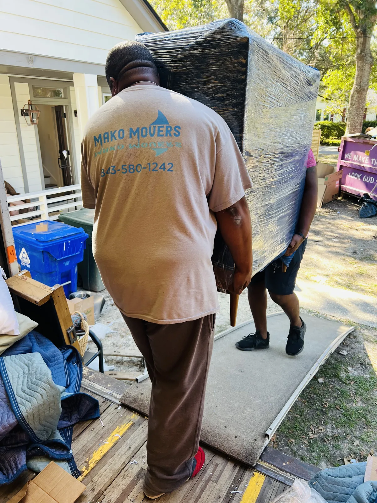 Mako Movers crew carrying wrapped furniture during a Charleston residential move