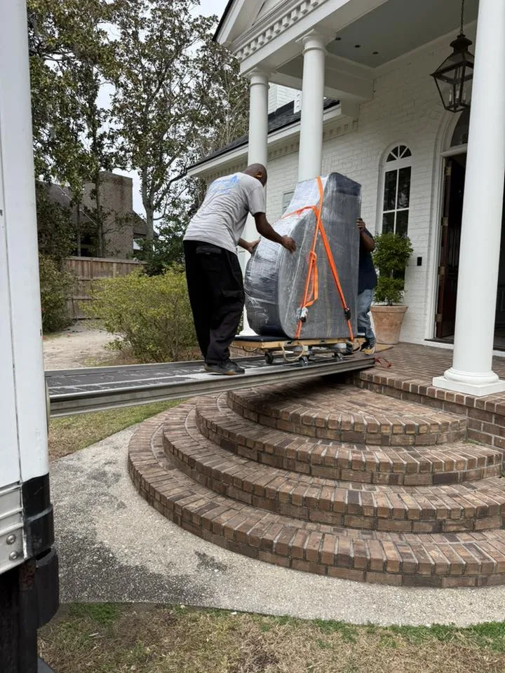 Mako Movers crew moving protected furniture down stairs at a Lowcountry home